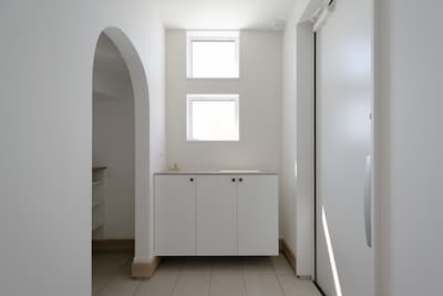 靴箱上のスクエア型の窓や土間スペースのアーチの入り口が可愛らしい玄関